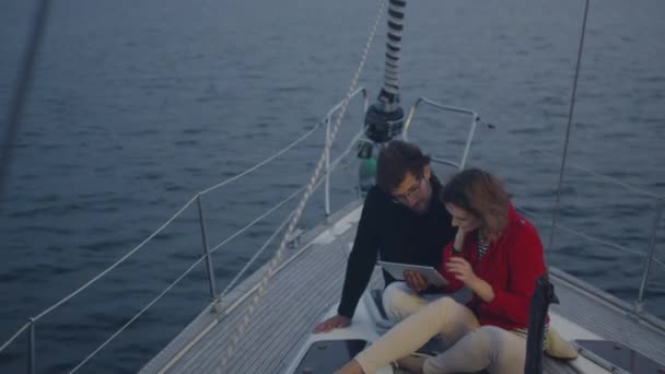 Pareja está usando la tableta en un yate en el mar . — Vídeos de Stock