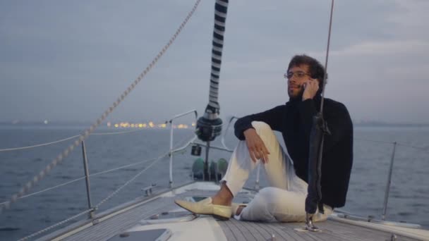 Jongeman is praten over een telefoon in de zee. — Stockvideo