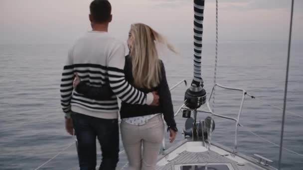 Par går på en modern segelbåt i havet. — Stockvideo