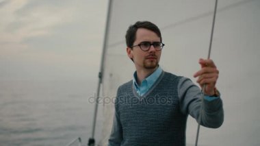 Adam dört gözle denizde yelkenli tekne.