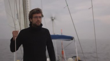 Adam dört gözle denizde yelkenli tekne.