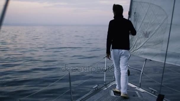 Ο άνθρωπος σε ιστιοπλοϊκό σκάφος στη θάλασσα κοιτάζοντας προς τα εμπρός. — Αρχείο Βίντεο