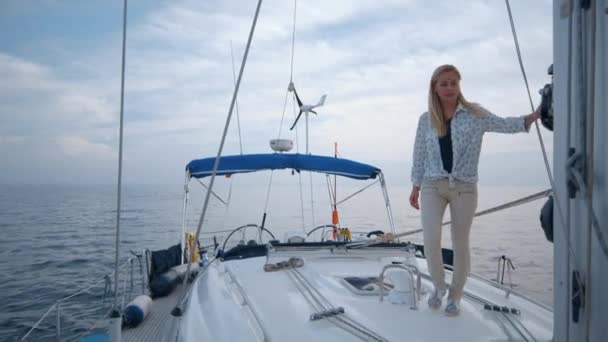 Young girl walks on modern sailing boat in the sea. — Stock Video