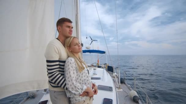 Молода пара розслабляється на вітрильнику в морі . — стокове відео