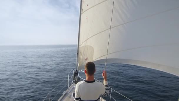 Jong koppel ontspannen op een jacht en kijken recht in de zee. — Stockvideo