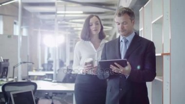 İki Ofis çalışanları yürüyüş. Tablet elinde tutan işadamı. 