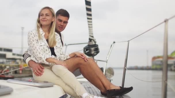 Hermosa pareja abrazándose en barco de vela mientras flotan desde el puerto . — Vídeo de stock