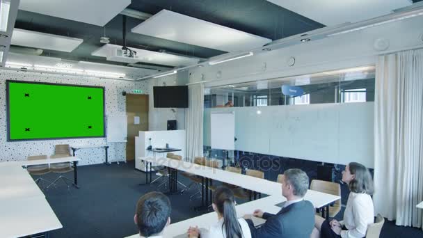 Eine Gruppe von Büroangestellten im Konferenzraum blickt auf den grünen Bildschirm. ideal für Mockup-Nutzung. — Stockvideo