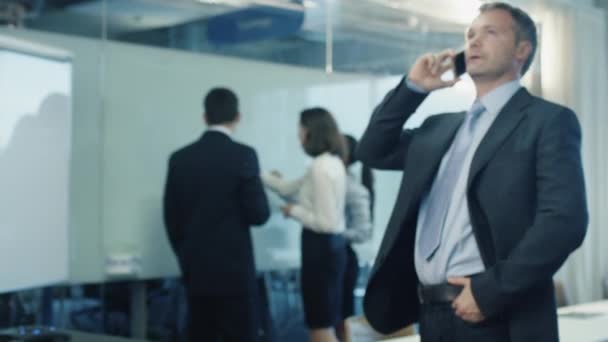 Businessman on the Phone in Crowded Office — Stock Video