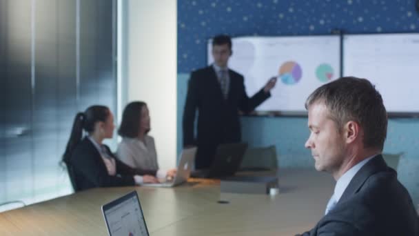 Uomo d'affari che lavora sul computer portatile durante la presentazione in sala conferenze — Video Stock