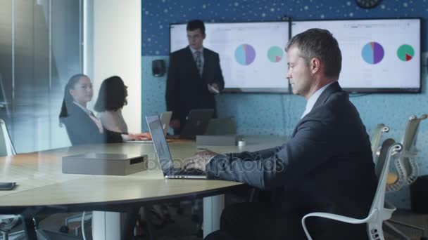 Uomo d'affari che lavora sul computer portatile durante la presentazione in sala conferenze — Video Stock
