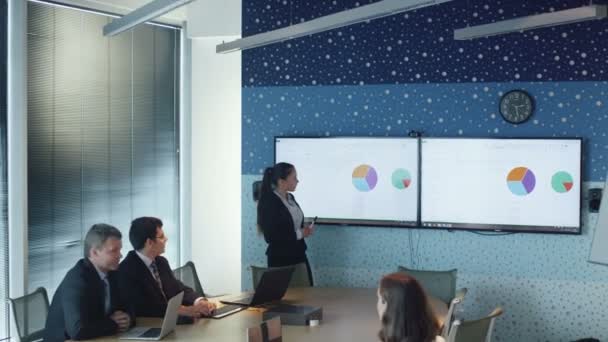 Affärskvinna gör presentationen för kollegor i konferensrum. — Stockvideo