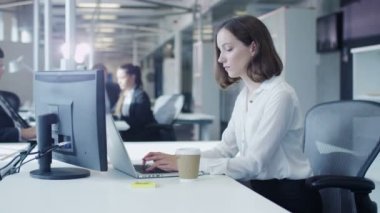Kadın memur Laptop ve içme kahve üzerinde çalışıyor