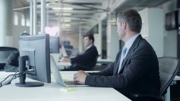 Dos trabajadores están trabajando y charlando en el lugar de trabajo en la oficina — Vídeos de Stock