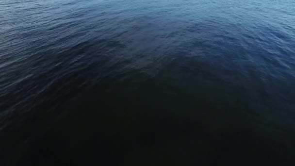 Luchtfoto drone schot van zee met lichtgolven in de avond. — Stockvideo