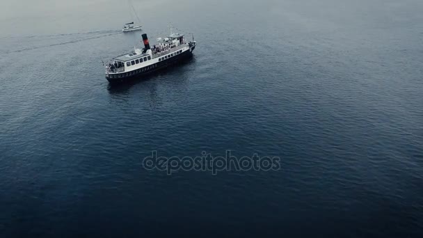 Aerial drone shot of old vintage cruise ferry and a small sailing boat in the sea. — Stock Video