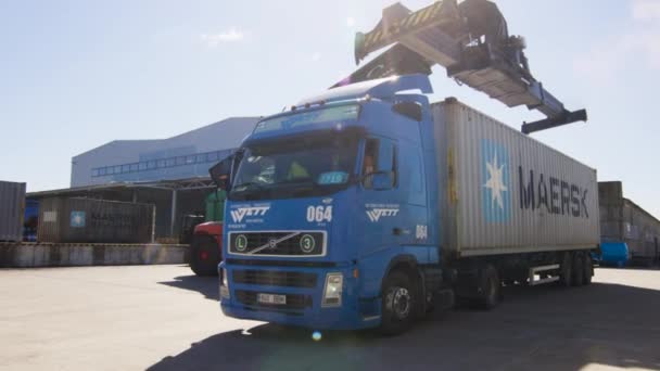 Container Handler charge le conteneur sur le camion dans le centre logistique . — Video