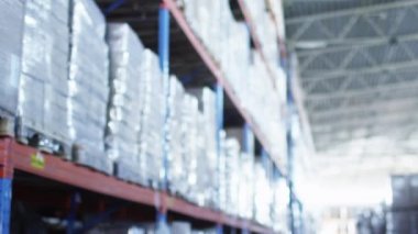 Lojistik ambar kadın işçi dizüstü bilgisayarda çalışıyor. Kulaklık takıyor.