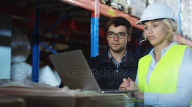Ambarı işçilerin çalışma üstünde Laptop birlikteyiz. Beyaz giyer zor şapka.