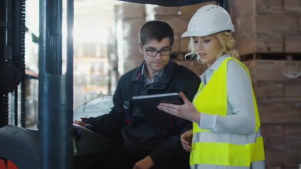 Gerente femenina de almacén logístico y operador de carretilla elevadora tienen conversación . — Vídeo de stock