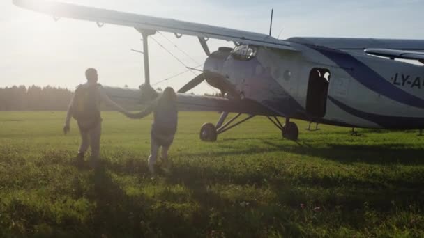 Personas con paracaídas que se trasladan a avión — Vídeo de stock