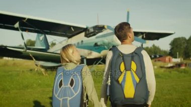 Adam ve kız uçak doğru yürüyüş paraşüt ile