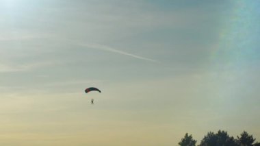 Gün batımı ışıkta Skydivers iken, atış