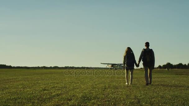 Couple se dirige vers l'avion dans l'aérodrome 