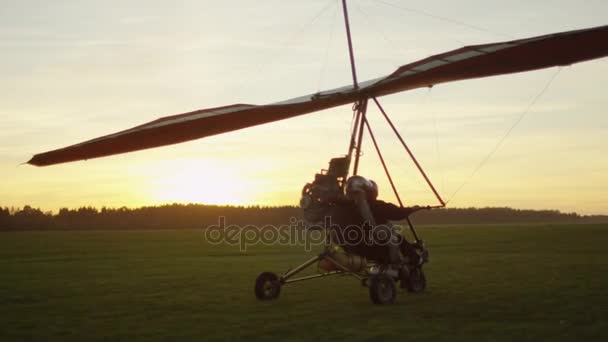 Bewegende gemotoriseerde Deltaplane bij zonsondergang — Stockvideo