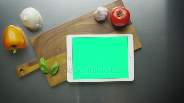 使用 tablet pc 在肖像模式下与蔬菜的厨房桌子上. — 图库视频影像