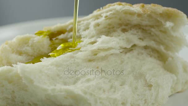 Verter aceite de oliva sobre pan blanco — Vídeo de stock
