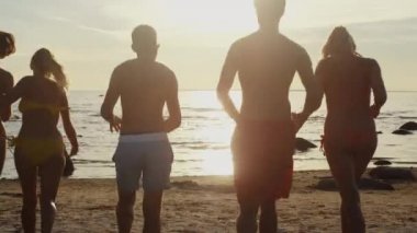 Bir grup genç insan'nde Günbatımı akan suyun ışık