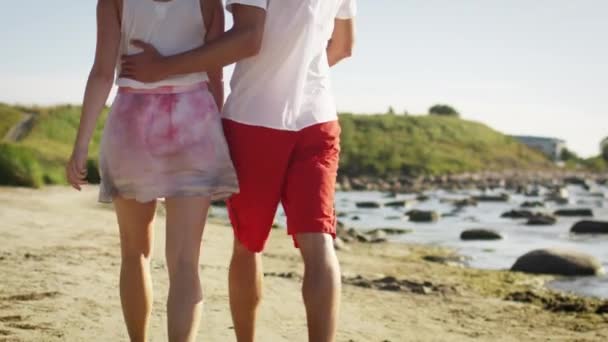 Ζευγάρι είναι το περπάτημα στην παραλία σε ηλιόλουστη μέρα. Αργή κίνηση 60 Fps. — Αρχείο Βίντεο