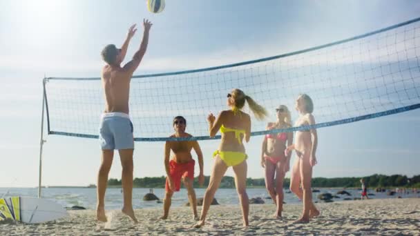 Skupina mladých lidí hrát volejbal na pláži — Stock video