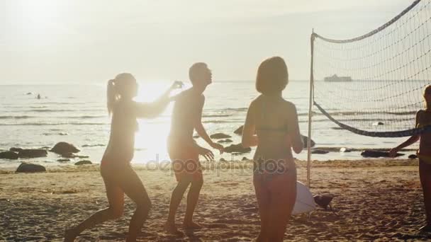 Plaj voleybolu'nde Günbatımı ışık oynayan gençlerin grup. Ağır çekim 60 Fps. — Stok video