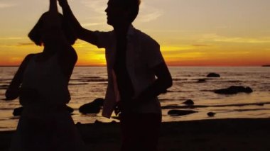 Çift dans sahilde günbatımı zamanı olduğunu.