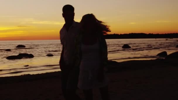 Casal está dançando na praia ao pôr do sol . — Vídeo de Stock