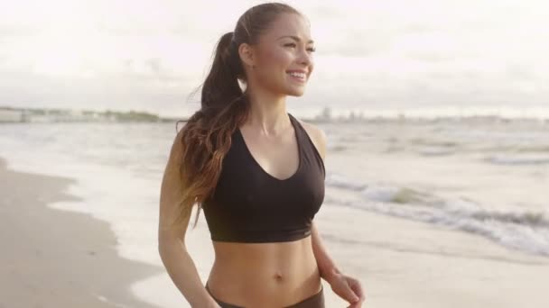 Menina está começando a correr na praia ao pôr do sol — Vídeo de Stock