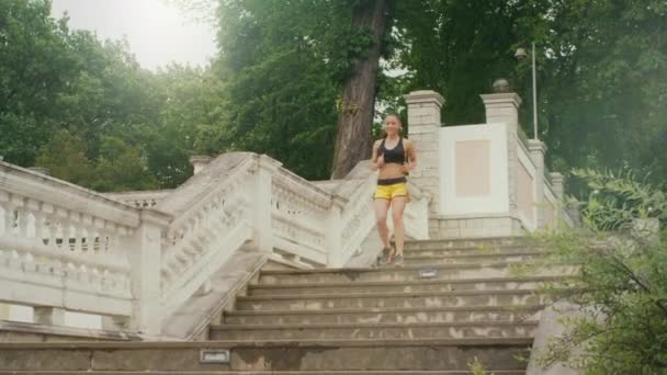 Chica joven está corriendo por las escaleras durante la carrera de la mañana . — Vídeo de stock