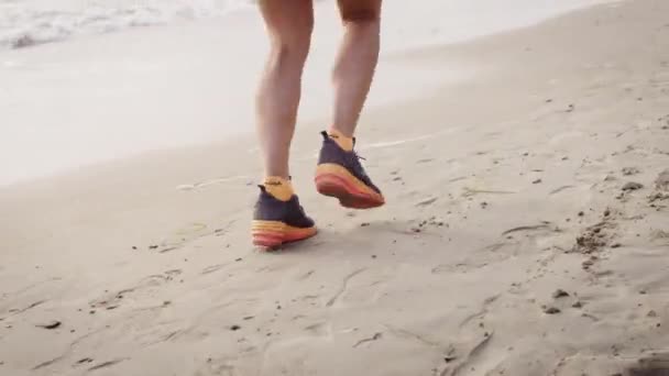 Tiro feminino corredores pernas em ação no praia — Vídeo de Stock