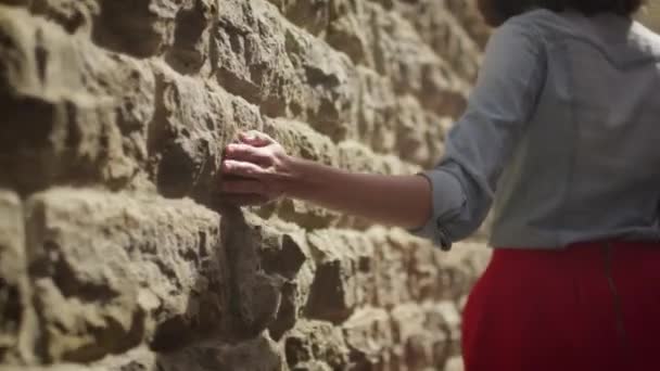 Chica está caminando a lo largo de la pared y tocarlo con la mano — Vídeo de stock