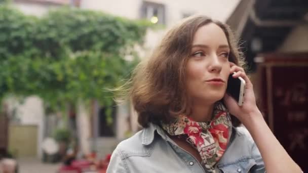 Mädchen telefoniert während eines Spaziergangs auf der Straße in einer europäischen Stadt — Stockvideo