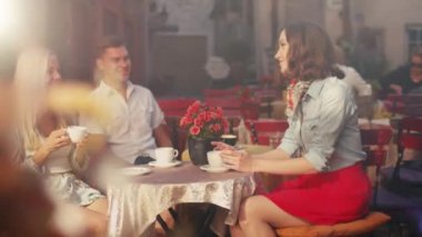 Talking içinde açık kafe mutlu gülümseyen genç insanlar vardır