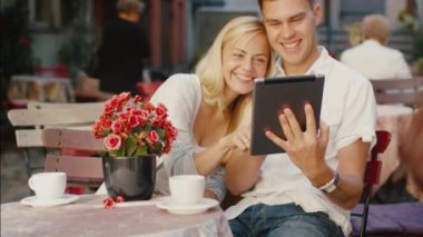 Genç gülümseyen iki kahve dükkanında Tablet PC'yi kullanma