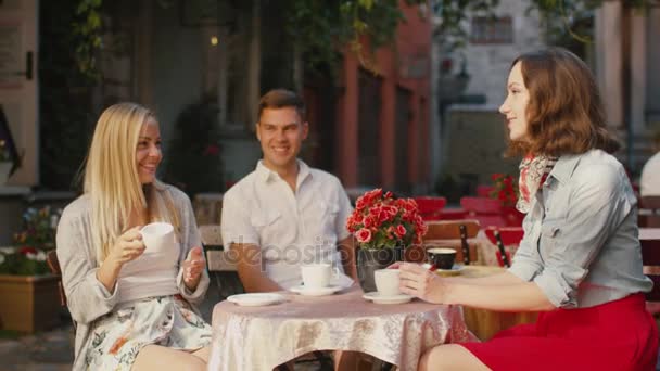 Jóvenes felices están hablando en la cafetería al aire libre — Vídeo de stock