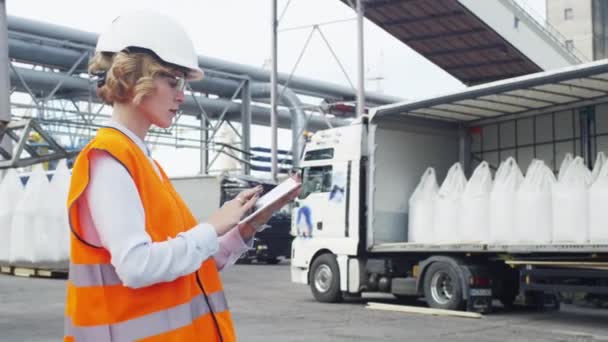 Frau mit Hut und Warnweste nutzt Tablet-PC in industriellem Umfeld — Stockvideo