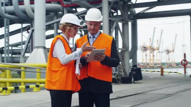 Geschäftsleute in Warnwesten mit Tablet im industriellen Umfeld — Stockvideo