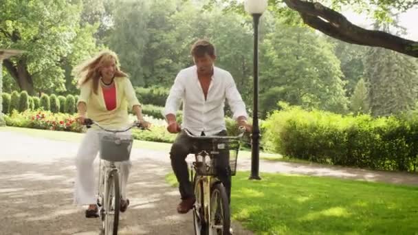 Heureux couple adulte à vélo dans le parc . — Video