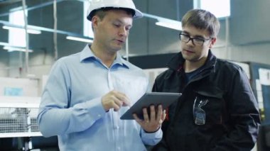 Baret mühendisi ve fabrika işçisi Tablet Pc kullanarak üretim tesisi