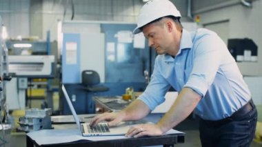 Mühendis fabrika üzerinde not defterinde Cad programı üzerinde çalışıyor